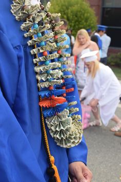 a person wearing a blue graduation gown with money attached to it