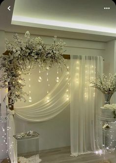 a white wedding arch decorated with flowers and lights