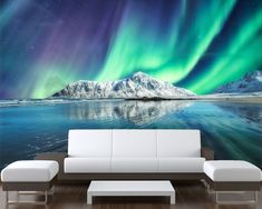 a living room with a couch, coffee table and wall mural depicting the northern lights