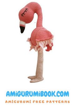 a crocheted pink flamingo sitting on top of a palm tree with its head in the air