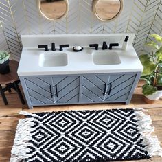 a white sink sitting next to a black and white rug