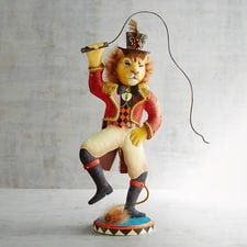 a lion figurine holding a microphone in its hand and wearing a top hat