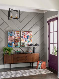 a living room with two paintings on the wall and a rug in front of it