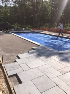 a man is walking near an empty swimming pool