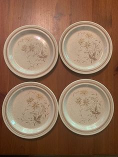 four plates sitting on top of a wooden table