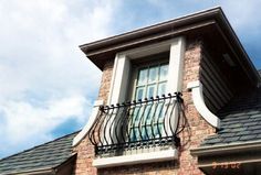 a brick building with a balcony and wrought iron railing