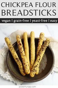 some bread sticks are in a bowl on a table