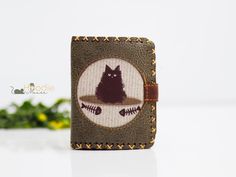 a small wallet with a cat embroidered on it