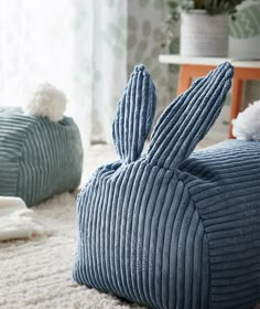 two blue pillows sitting on top of a white rug