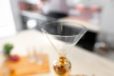 an empty martini glass sitting on top of a counter