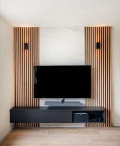 a flat screen tv sitting on top of a black entertainment center in a living room