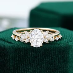 a diamond ring sitting on top of a green velvet cushion