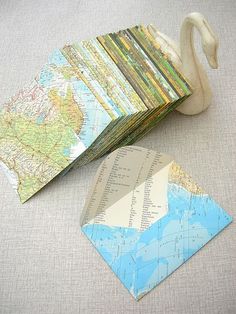 several folded maps are sitting next to a swan