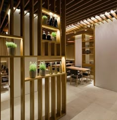 an empty restaurant with wooden shelves filled with plants