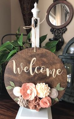 a wooden sign that says welcome with flowers on it