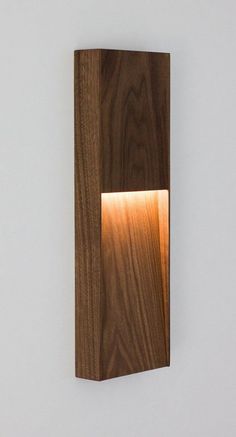 a wooden light fixture mounted on the side of a wall