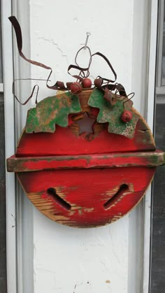 an old red wooden sign hanging from the side of a door with ivys on it