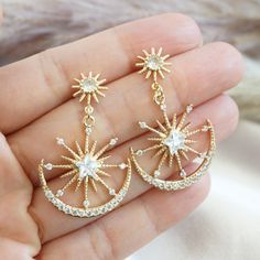 "This gold statement earrings feature double star burst design with a smaller starburst posts attached to a sparkly larger sunburst charm nestled in a crescent moon.  A unique large celestial earrings perfect for going out or whenever you want an extra pop of sparkle. DIMENSION: ----------------- Earrings : 1 inch wide x 1.5 inch long For other celestial jewelry, click here : https://www.etsy.com/shop/YsmDesigns?ref=seller-platform-mcnav&search_query=celestial PACKAGING/ GIFTING: --------------- Gold Celestial Jewelry, Gold Star-shaped Celestial Earrings, Gold Star-shaped Crystal Earrings For Pierced Ears, Gold Celestial Star Earrings, Gold Starburst Celestial Earrings, Celestial Packaging, Celestial Earrings, Earrings Double, Starburst Earrings