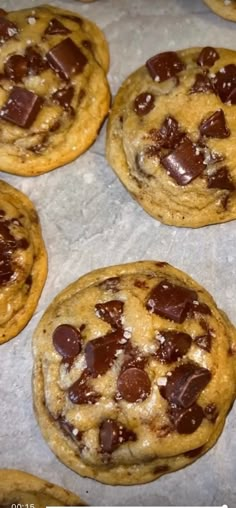 several chocolate chip cookies sitting on top of a baking sheet