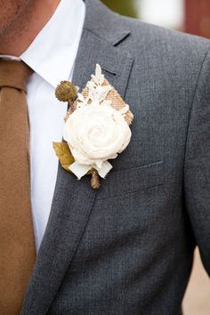 a man wearing a suit and tie with a boutonniere on his lapel