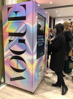 a group of people standing next to a vending machine in a store filled with customers