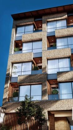 a tall brick building with lots of windows and balconies on the top floor