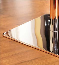 a triangle shaped mirror sitting on top of a wooden table