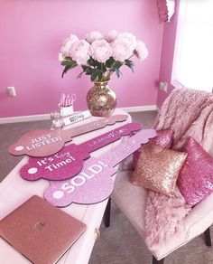 a room with pink walls and furniture in the corner, along with decorative signs that spell out i love you