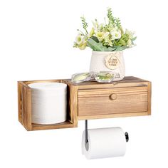 a wooden shelf holding two rolls of toilet paper and a vase with flowers on it