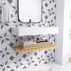 a bathroom with black and white tiles on the walls, a sink and mirror above it