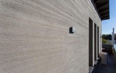 the side of a building that is made out of concrete and has a light fixture on it