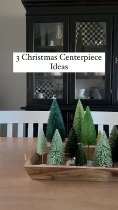 three christmas centerpieces with trees in a wooden tray