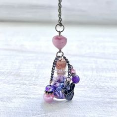 a necklace with beads and charms hanging from it's side on a table top