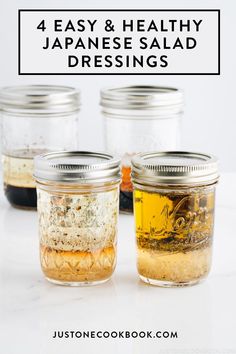 four jars filled with different types of food on top of a white counter next to each other