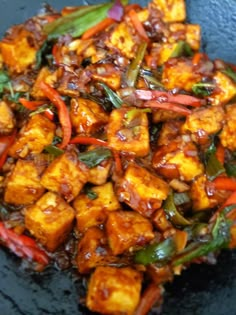 tofu and peppers are being cooked in a wok