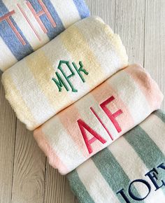 three towels with the word aff on them sitting next to each other in front of a wooden surface