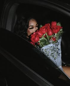 a woman in a car with red roses