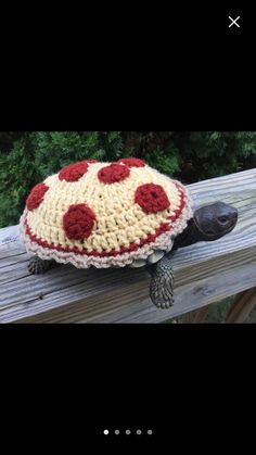 a crocheted turtle sitting on top of a wooden table