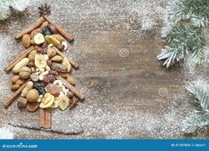 a christmas tree made out of nuts and cinnamons on a wooden table with snow