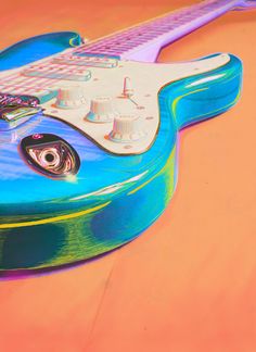 an electric guitar is painted bright blue and pink with the colors of the rainbow on it