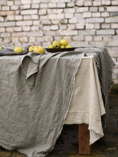 a table with some fruit on it and a brick wall in the backround