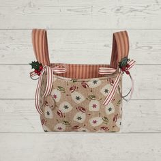 a small purse with red and white stripes on the front, decorated with holly berries