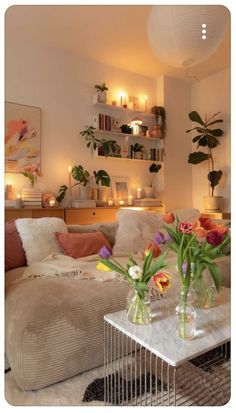 a living room filled with lots of furniture and flowers on top of a coffee table