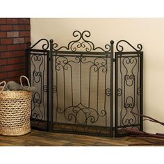 a black iron fireplace screen next to a basket