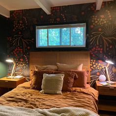 a bed room with a neatly made bed and two lamps on either side of the bed