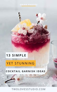 a glass filled with ice and garnish sitting on top of a table next to a