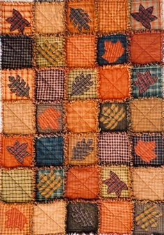 an orange and blue patchwork quilt with different designs on it's sides, including leaves