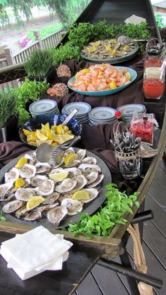 a table filled with food and drinks on top of a wooden floor covered in black cloths