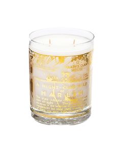 a white candle with gold foil on the top and bottom, sitting in front of a white background