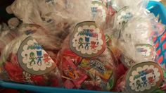 a blue basket filled with lots of different types of candies in plastic wrappers